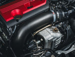 AWE carbon turbo inlet tube – fitted to a Honda Civic Type R FL5, close-up beside the red engine cover - AWE Exhausts Thumbnail