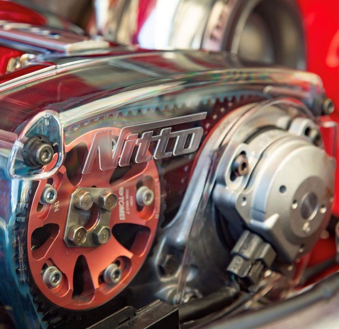 Nitto clear timing belt cover fitted over red adjustable cam gears