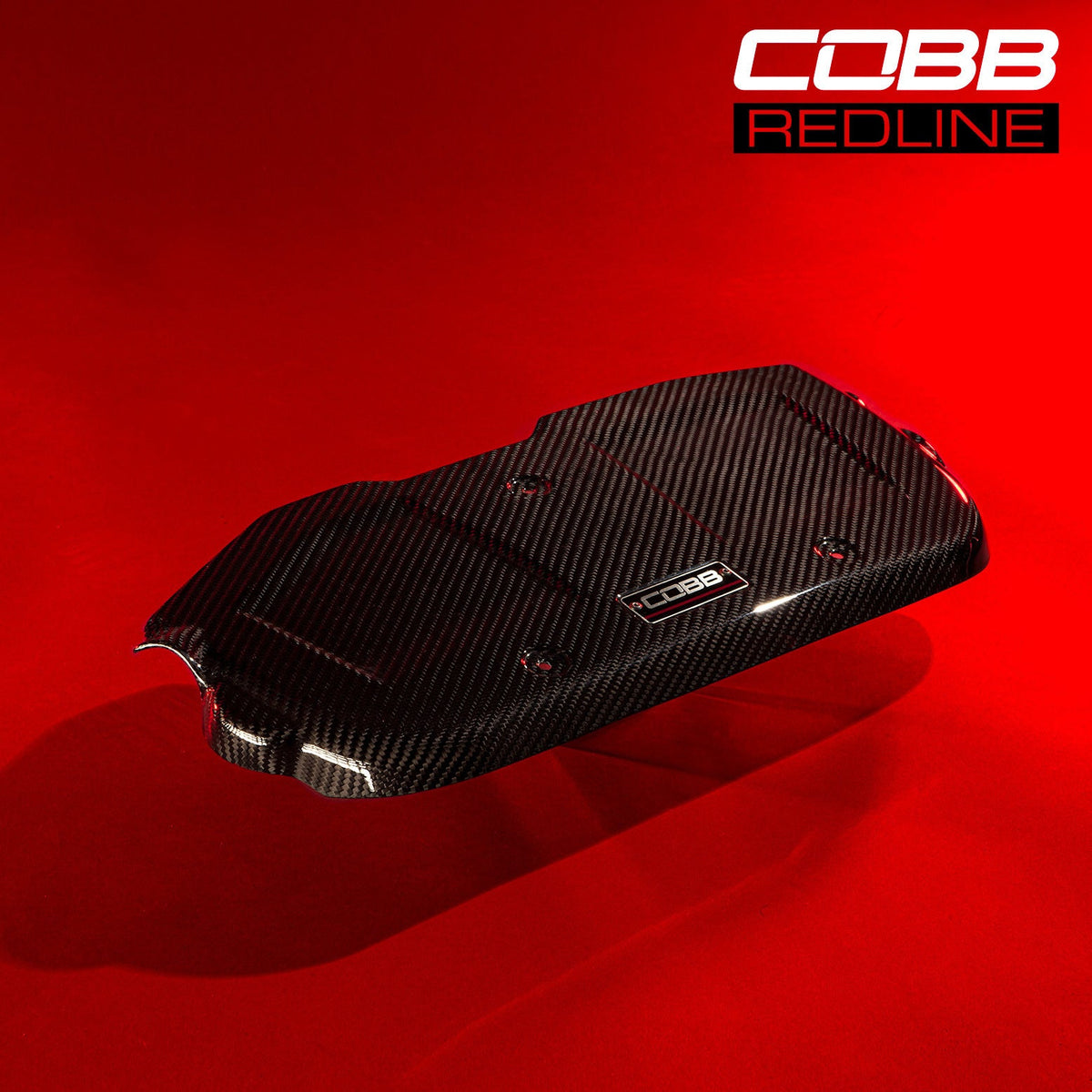 COBB Redline carbon fibre engine cover – Subaru WRX VA – cover on red backdrop
