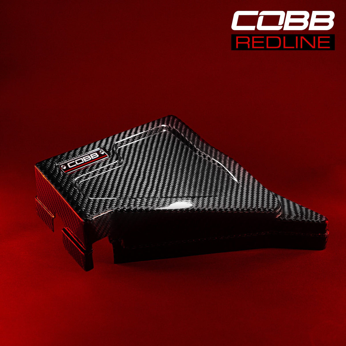 COBB Redline carbon fibre fuse cover – Subaru WRX and STI – cover on a red-lit background