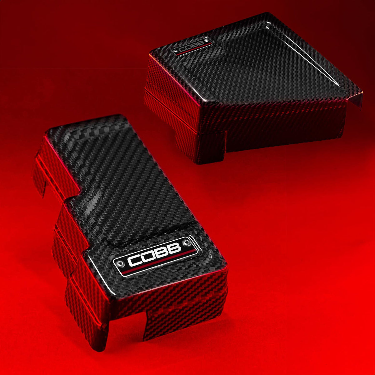 COBB Redline carbon fibre fuse cover kit – Subaru WRX VB – both covers on red backdrop