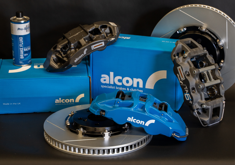 Alcon brake components including calipers and rotors on a black background - Alcon