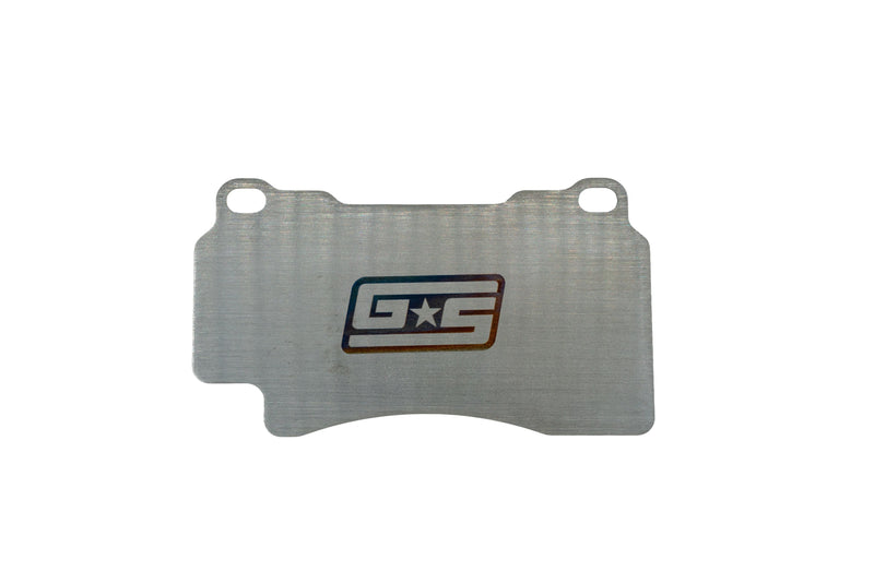 GrimmSpeed titanium front brake shim for the WRX STI (GD / GR / GV / VA) - front face with GS logo - GrimmSpeed