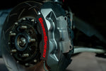 GrimmSpeed titanium front shim in place in a 4-piston caliper (product illustration) - GrimmSpeed Thumbnail