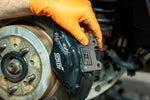 GrimmSpeed titanium rear shim being fitted behind a pad in a Subaru WRX STI Brembo 2-piston rear caliper - GrimmSpeed Thumbnail