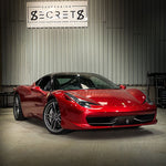 Red Ferrari 458 parked under the Suspension Secrets sign - Suspension Secrets Thumbnail
