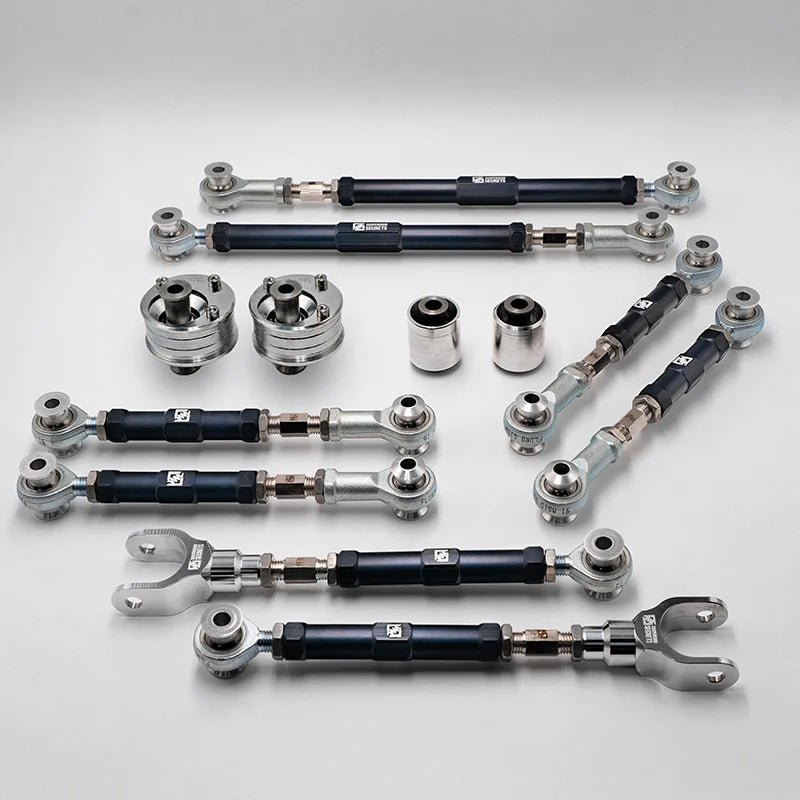 Suspension Secrets full kinematics kit, adjustable arms and solid bushes laid out on a white background - Suspension Secrets