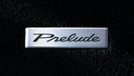 Close-up of the brushed metal Prelude logo plate on the Honda Access floor mat - Honda - Genuine Thumbnail