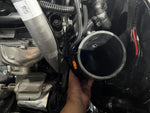 MST silicone turbo inlet pipe being fitted to the turbo in a BMW B58 engine bay - MST Performance Thumbnail